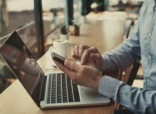Person on laptop and phone