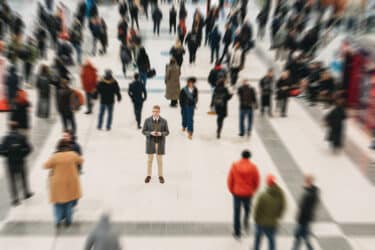 Person standing amidst a busy crowd. Phone from China.